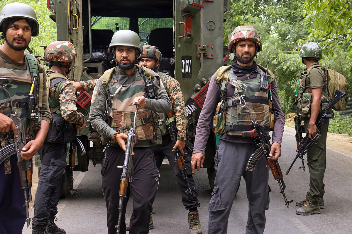 PTI : Security personnel stand guard during an encounter with militants in Kulgam. | 